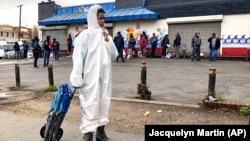 Egni gorag kostýumly 12 ýaşly oglan mugt berilýän ynsanperwer ýardamyny almak üçin, öz nobatyna garaşýar. Waşington, ABŞ.