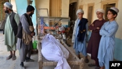 Relatives stand around the dead body of a victim of a suicide bomb attack in Kandahar on March 21. 
