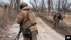 O fotografie difuzată Ministerul rus al Apărării pe 19 februarie 2024 arată doi soldați ai unităților de geniu în timp ce caută mine în orașul Avdiivka din estul Ucrainei. Forțele rusești spun că au preluat controlul complet al orașului.