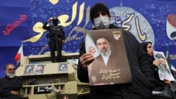 A man holds a picture of Iran's new supreme leader, Mojtaba Khamenei, at a funeral ceremony in Tehran on March 11 for Iranian military commanders killed in strikes.