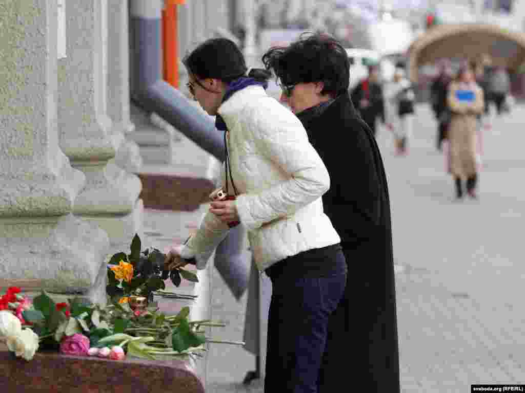 People place flowers in a makeshift memorial outside the subway station.