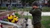 A Ukrainian servicewomen in Kherson cries as she lays flowers to commemorate those killed in the war as the city marks one year since Ukraine retook the city from occupying Russian forces on November 11, 2022. 