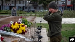 A Ukrainian servicewomen in Kherson cries as she lays flowers to commemorate those killed in the war as the city marks one year since Ukraine retook the city from occupying Russian forces on November 11, 2022. 