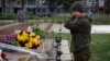 A Ukrainian soldier in Kherson cries as she lays flowers to commemorate those killed in the war as the city marks one year since Ukraine retook the city from occupying Russian forces.