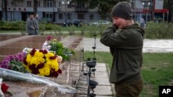 A Ukrainian soldier in Kherson cries as she lays flowers to commemorate those killed in the war as the city marks one year since Ukraine retook the city from occupying Russian forces.