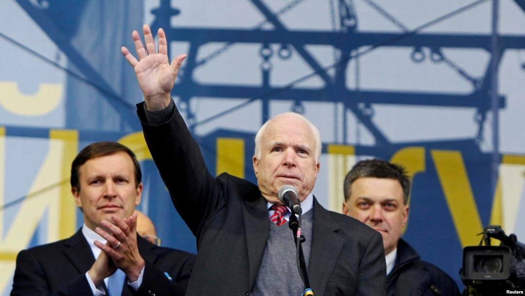 U.S. Senator John McCain (center) waves to pro-European-intergration protesters during a mass rally at Independence Square in Kyiv on December 15. 