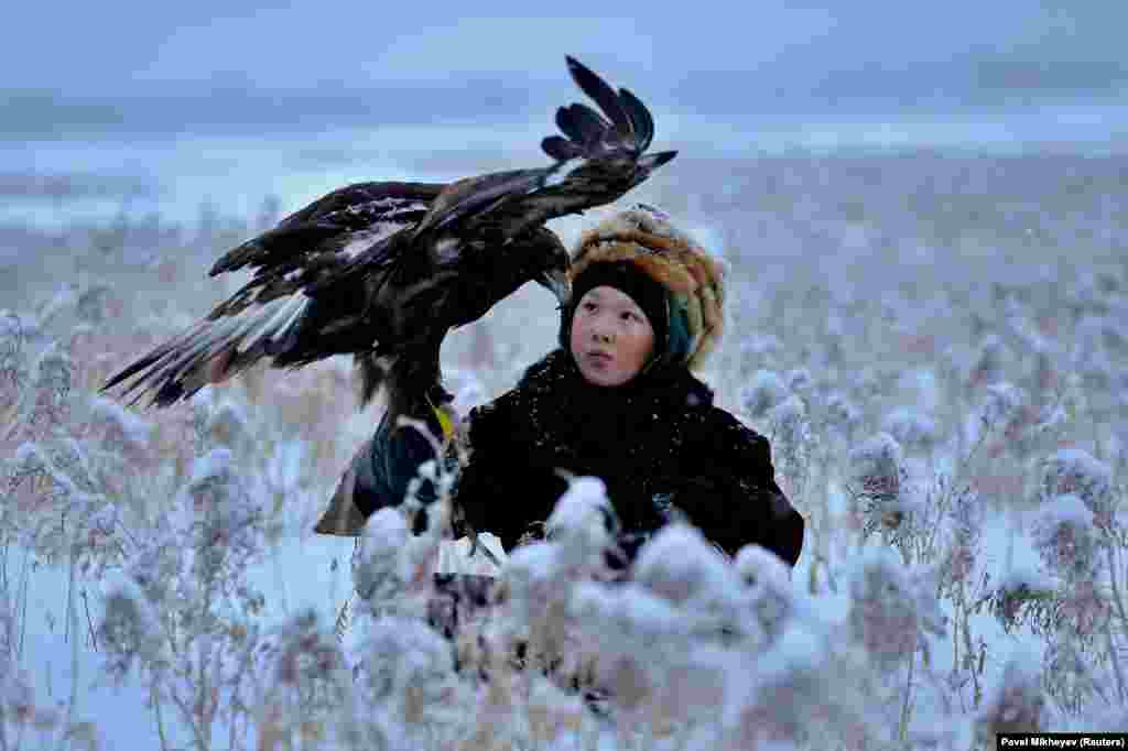 A participant holds his tamed golden eagle during a traditional hunting contest near the town of Esik in Kazakhstan&#39;s Almaty region on December 5. (Reuters/Pavel Mikheyev)
