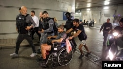 Ljudi se kreću prema skloništu nakon raketnog napada Irana na Izrael, u Tel Avivu, 13. juna