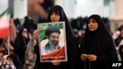 ایرانۍ ښځې د ایران د نوي مشر مجتبی خامنه ای انځور په لاس کې نیولی دی 