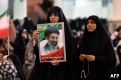 Іранка тримає фотографію верховного лідера Ірану аятолли Моджтаби Хаменеї під час молитви Ід аль-Фітр у мечеті в Тегерані 21 березня 2026 року