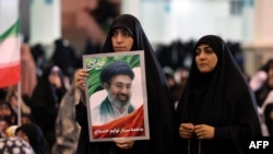 O femeie iraniană cu o fotografie a liderului suprem iranian, Mojtaba Khamenei, în timpul rugăciunilor de Eid al-Fitr, care marchează sfârșitul lunii sfinte musulmane Ramadan, la o moschee din Teheran, pe 21 martie 2026.