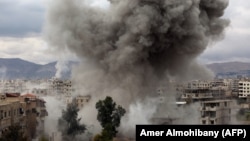 У места бомбового удара в Восточной Гуте, осажденном районе в пригороде Дамаска. 22 февраля 2018 года.