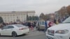 Crowd cheer and chant as they surround a car with Ukrainian soldiers in Kherson Freedom Square