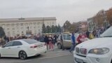 Crowd cheer and chant as they surround a car with Ukrainian soldiers in Kherson Freedom Square