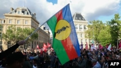 A protester holds the flag of New Caledonian nationalists at a demonstration in Paris on May 16, 2024.