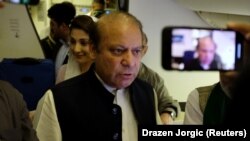 UAE -- Ousted Pakistani Prime Minister Nawaz Sharif gestures as he boards a Lahore-bound flight due for departure, at Abu Dhabi International Airport, uly 13, 2018