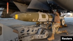 Американски военен прикрепя боеприпасна система GBU-31 към изтребител F-15E Strike Eagle на 19 декември 2025 като част от подготовката за американската операция "Ястребово око" срещу позиции на "Ислямска държава" в Сирия.