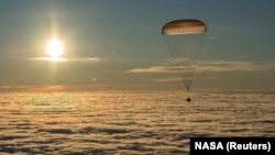 The Soyuz MS-06 capsule carrying the crew of Joe Acaba and Mark Vande Hei of the United States and Alexander Misurkin of Russia descends beneath a parachute just before landing in a remote area in Kazakhstan on February 28.