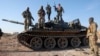 Syrian rebels stand atop a seized military armored vehicle on the outskirts of Hama. 