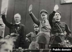 За пару месяцев до мятежа. Ион Антонеску (слева), Хориа Симпа (справа) и посол нацистской Германии приветствуют участников парада легионеров. Бухарест, 1940 год