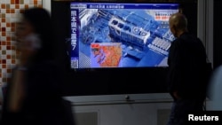 Locuitori din Tokyo privesc știrile despre cutremurul din Kumamoto, pe 28 iulie 2026.