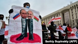Зображення на плакаті російського президента Володимира Путіна (ліворуч) і Олександра Лукашенка під час акції до Міжнародного дня солідарності з Білоруссю. Київ, 7 лютого 2021 року 