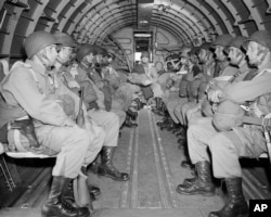 Американські десантники у військовому літаку, який ширяє над Ла-Маншем на шляху до узбережжя Франції в Нормандії, 6 червня 1944 року