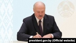 Alyaksandr Lukashenka signs the amendments into law in Minsk on May 24.