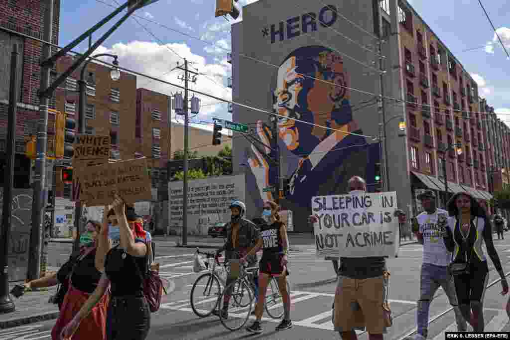 Black Lives Matter demonstrators march past a mural of civil right leader and US Representative John Lewis in the wake of the Atlanta Police deadly shooting of Rayshard Brooks in Atlanta, Georgia, USA, 16 June 2020.