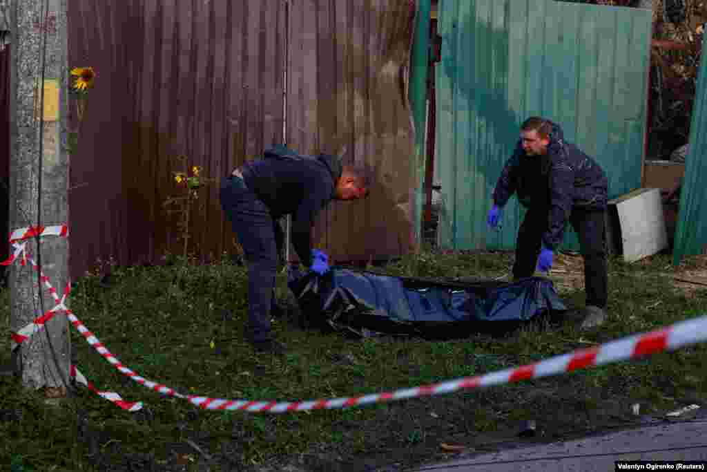 Працівники комунальних служб готуються вивезти тіло підлітка, який загинув унаслідок російського ракетного удару по місту Вишгороду, Київська область, 30 вересня 2026 року