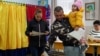 A man holds a child as he casts his vote in the parliamentary elections in Joita, outside Bucharest, on December 1.