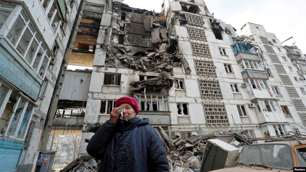 A local resident cries next to the building where her destroyed apartment is located in the besieged city of Mariupol on March 27. 