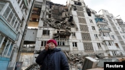 A local resident cries next to the building where her destroyed apartment is located in the besieged city of Mariupol on March 27. 