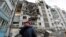 A local resident cries next to the building where her destroyed apartment is located in the besieged city of Mariupol on March 27. 