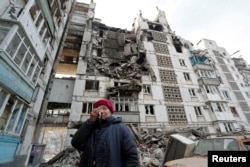  70-годишна жена плаче на фона на опустошен от ракети блок, където е бил апартаментът ѝ, 27 март 2022 година 