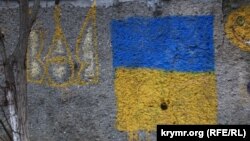 На фото: прапор і герб на стіні в одному із селищ Південного берегу Криму