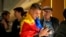 A supporter of the pro-EU Party of Action and Solidarity (PAS) draped in the Moldovan flag smiles as he checks results on a phone in Chisinau after parliamentary elections on September 28.