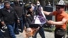 Kyrgyz men burn a placard during an anti-gay rally in Bishkek in April 2021.