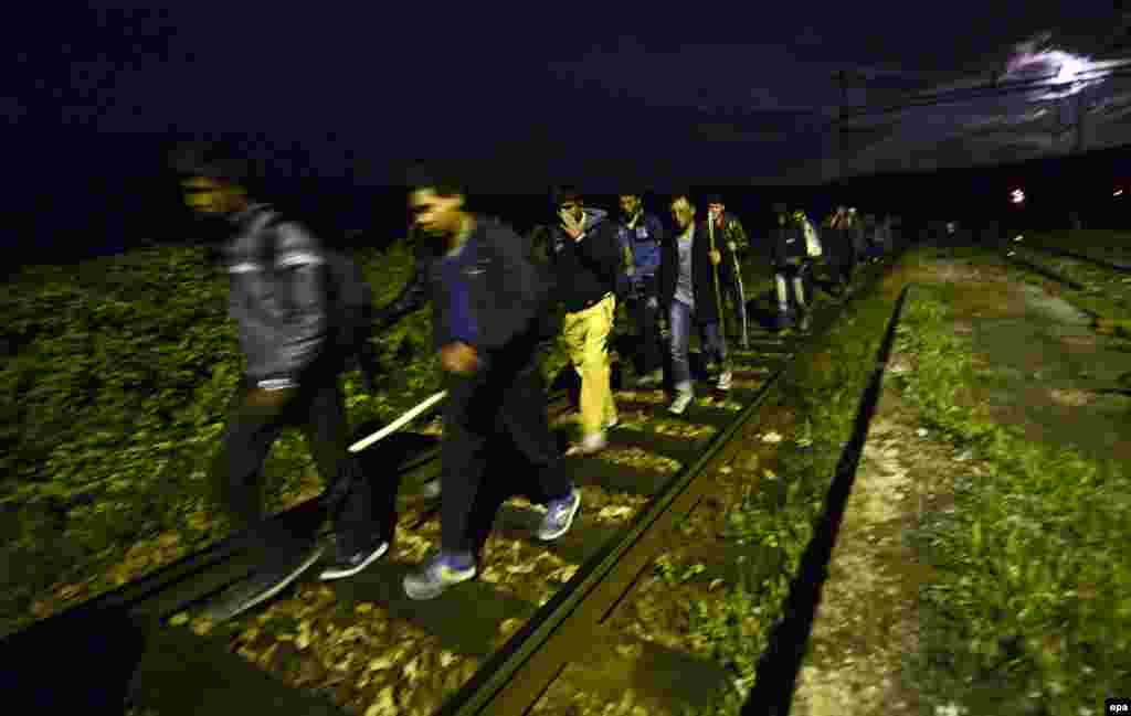 Migrants walk on railroad tracks during the night in order to avoid police detection between Gevgelija and Veles in Macedonia. (epa/Georgi Licovski)&nbsp;