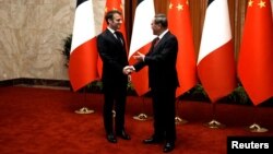 Premýer-ministr Li Kiang prezident Makrony Halk zalynda garşy aldy.