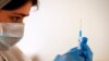 A health-care worker prepares a dose of Sputnik V vaccine against COVID-19. Hundreds of people in Moscow demonstrated on June 26 in opposition to what they said were "mandatory" vaccinations.