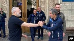 The director-general of the International Atomic Energy Agency, Rafael Grossi (right), and Ukrainian Energy Minister Herman Halushchenko shake hands in Kyiv on September 3.