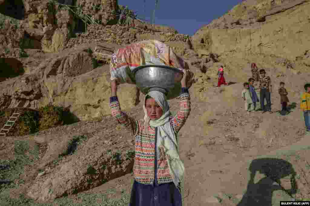 Copii etnici Hazara merg spre un râu aflat lângă satul lor. Populația minoritară Hazara trăiește în peșteri, așa cum au trăit cu secole în urmă strămoșii lor din Bamiyan, Afganistan.