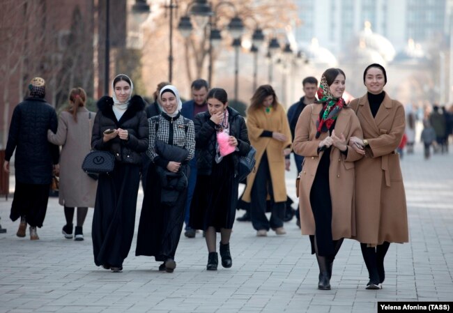 Women walk down a street in the Chechen capital, Grozny. There have been reports that police have been stopping people in Chechnya and checking their phones for evidence they are subscribed to 1ADAT.