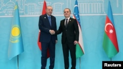 Türkiyə prezidenti Rəcəb Tayyib Ərdoğan Ankarada Türk Dövlətləri Təşkilatının Dövlət Başçıları Şurasının iclası zamanı Azərbaycanın xarici işlər naziri Ceyhun Bayramovla əl sıxışır.