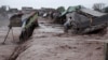 Men collect try to collect their belongings from a makeshift shop on the outskirts of Peshawar after it was hit by flooding following torrential rain in Khyber Pakhtunkhwa Province on April 3. 