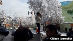 تصویری در شبکه های  اجتماعی منتشر شد که براساس آن، دختری در نزدیکی خیابان انقلاب تهران روسری خود را به یک چوب وصل کرده و بر روی یکی از پست‌های انتقال برق ایستاده است