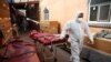 Un angajat în echipament special la o moschee din Birmingham, Marea Britanie, transformată temporar în morgă