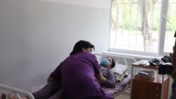 Медик осматривает беременную пациентку, поступившую в медучреждение во время пандемии.