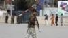 An Afghan policeman walks near the site of an explosion in Kabul on March 21